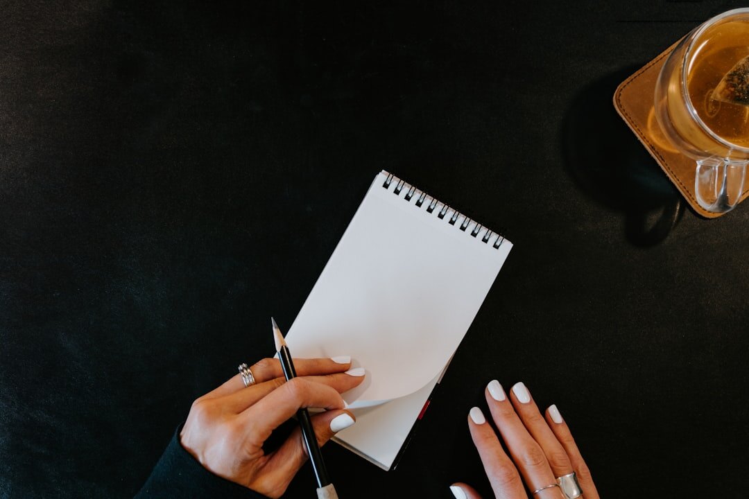 person writing notes in notebook